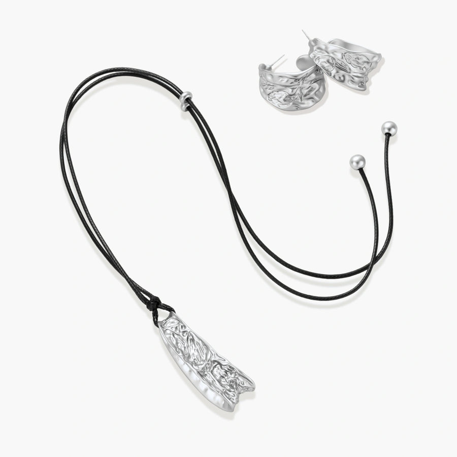 Textured silver jewelry set with floral engravings featuring adjustable cord necklace and matching hoop earrings