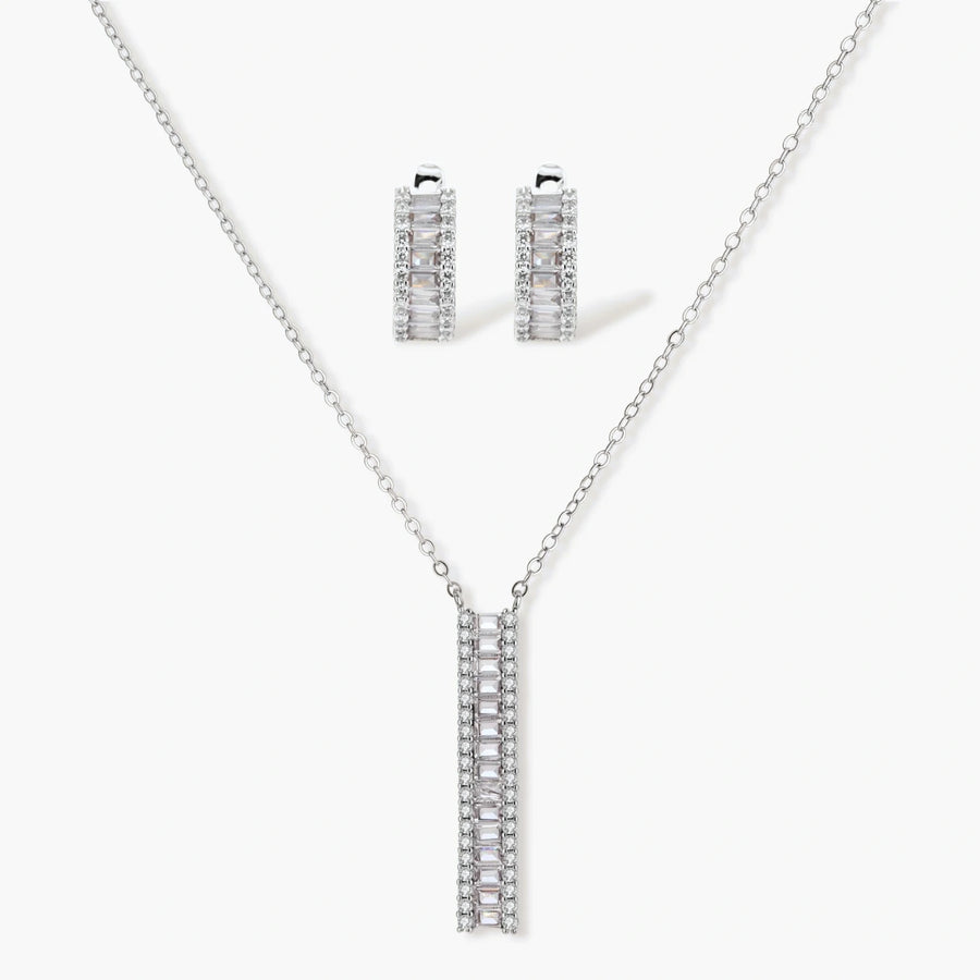 White gold plated necklace with vertical cubic zirconia pendant and matching hoop earrings on neutral background
