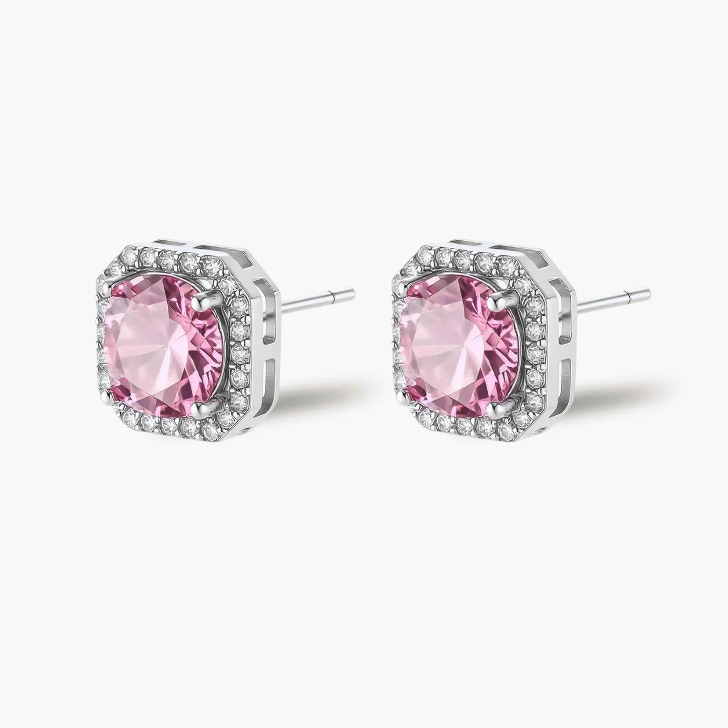 Pink moissanite studs in octagonal sterling silver halo settings with sparkling accent stones on cream background.