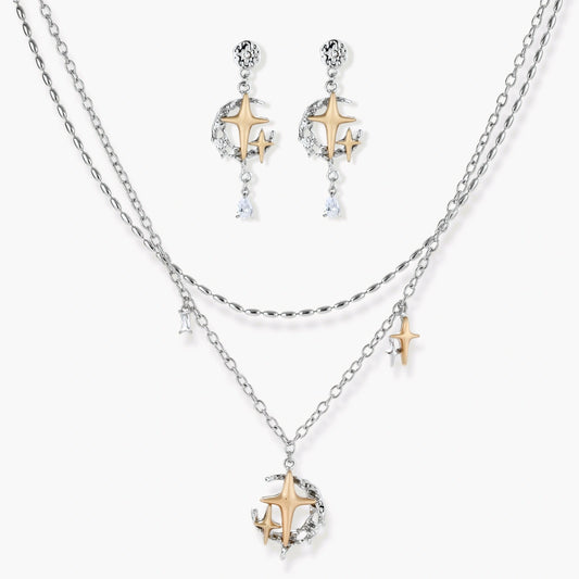 Delicate eco-brass jewelry set featuring gold star and silver moon crescents with clear zirconia crystal drops on cream background
