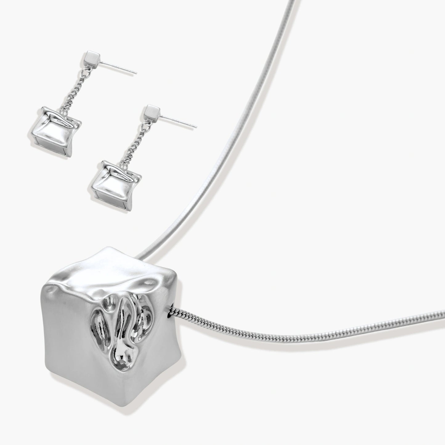 Geometric jewelry set with textured cube pendants on chains, featuring eco-zinc alloy in silver and gold finishes.