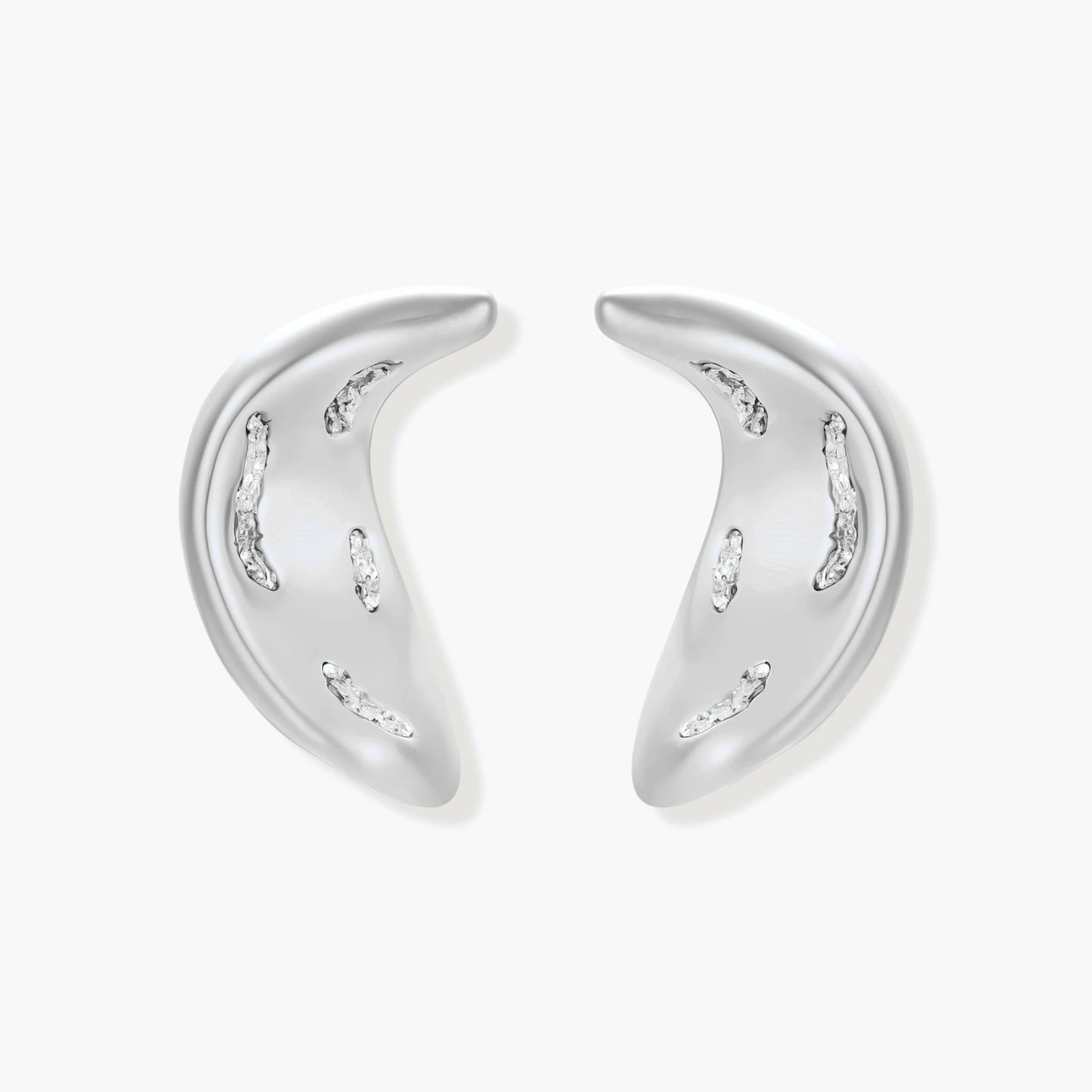Crescent moon shaped pendant and earrings in eco-zinc alloy with curved crystal inlay patterns on light background.