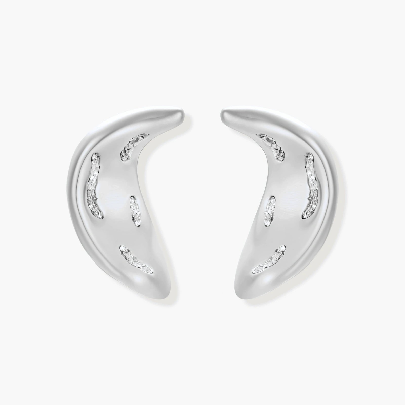Crescent moon shaped pendant and earrings in eco-zinc alloy with curved crystal inlay patterns on light background.