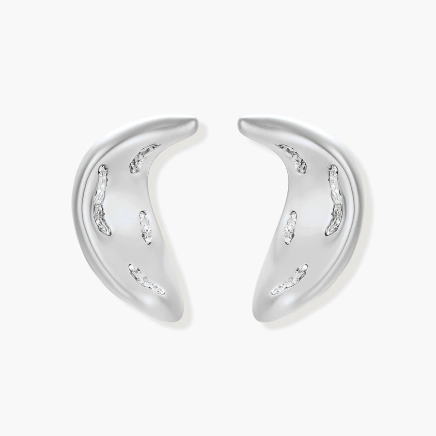 Crescent moon shaped pendant and earrings in eco-zinc alloy with curved crystal inlay patterns on light background.