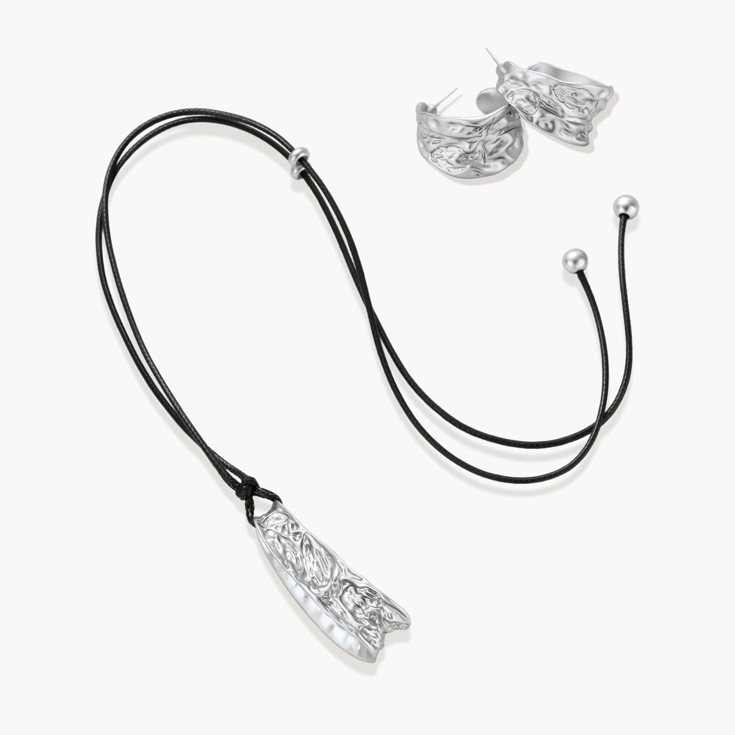 Textured silver jewelry set with floral engravings featuring adjustable cord necklace and matching hoop earrings