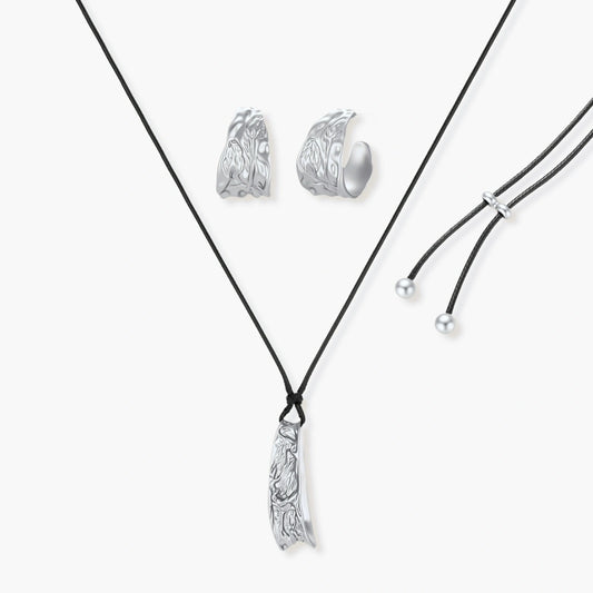 Textured silver jewelry set with floral engravings featuring adjustable cord necklace and matching hoop earrings